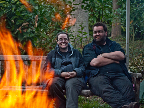 As with all good charcoal burns, a nearby fire is lit to provide heat and for cooking. Two volunteers on the charcoal-making course enjoy a break.